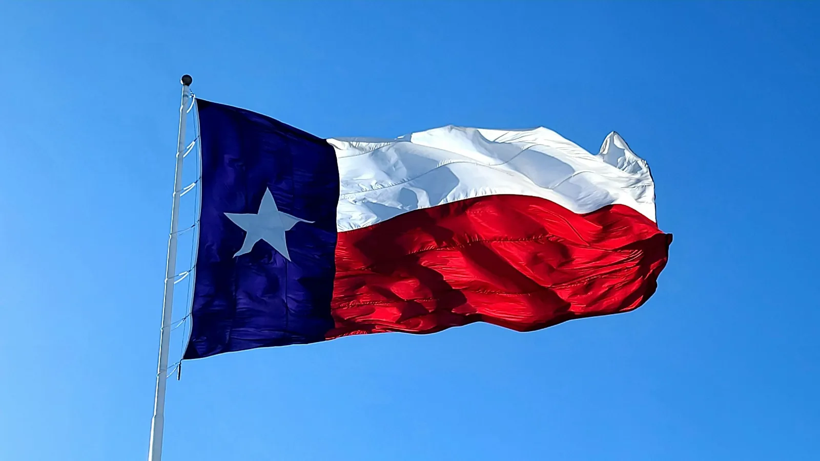 Texas flag against a blue sky